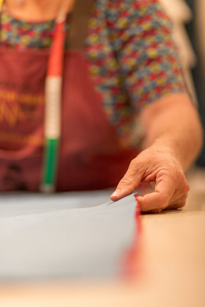 Christelle Bourassier mesurant un tissu à l’atelier